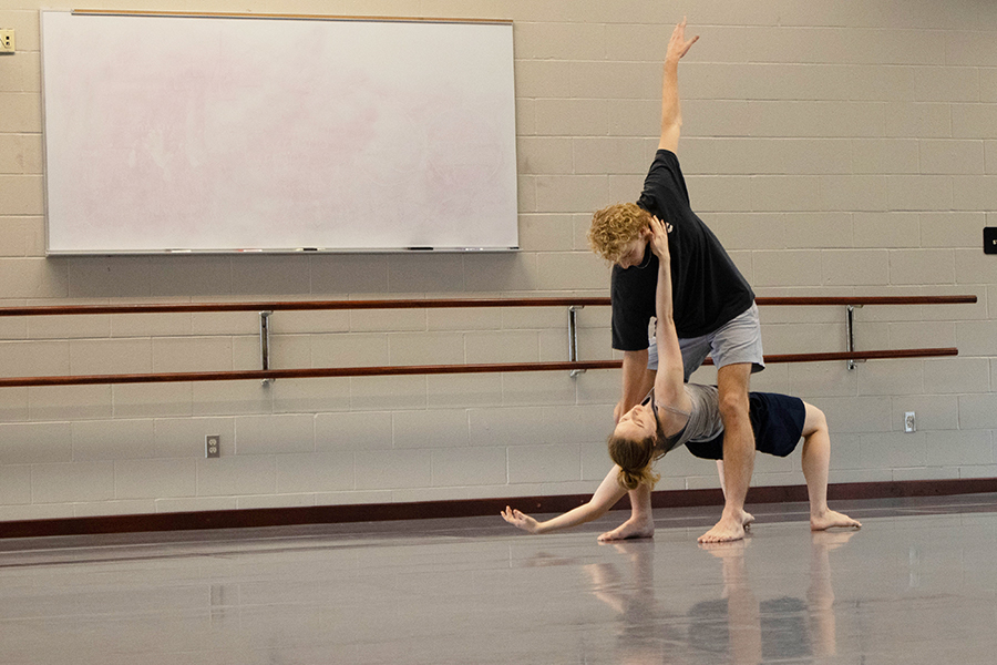 Two dancers perform in a studio.
