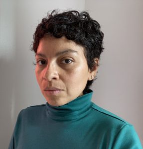 A person in a green turtleneck sweater