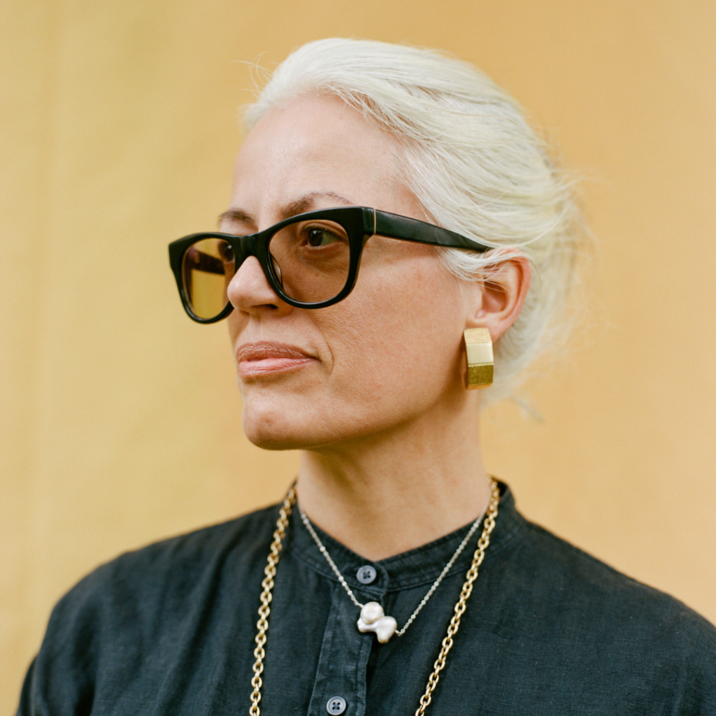 there is a woman wearing glasses and a necklace with a cross on it