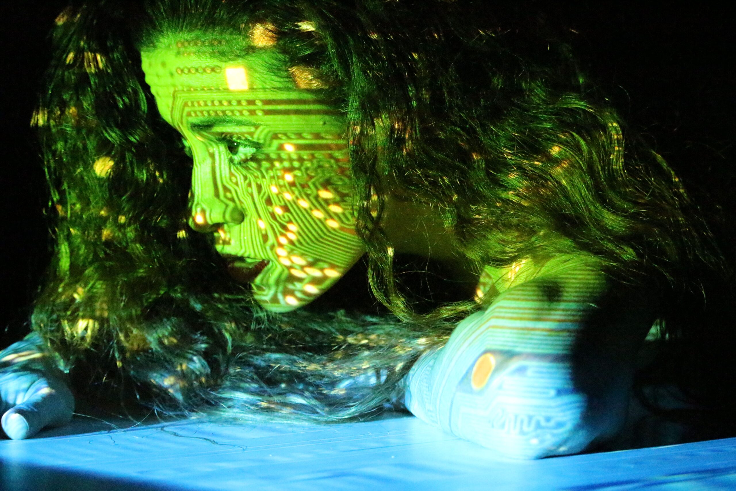a light green and blue digital chip picture is projected on a woman's face