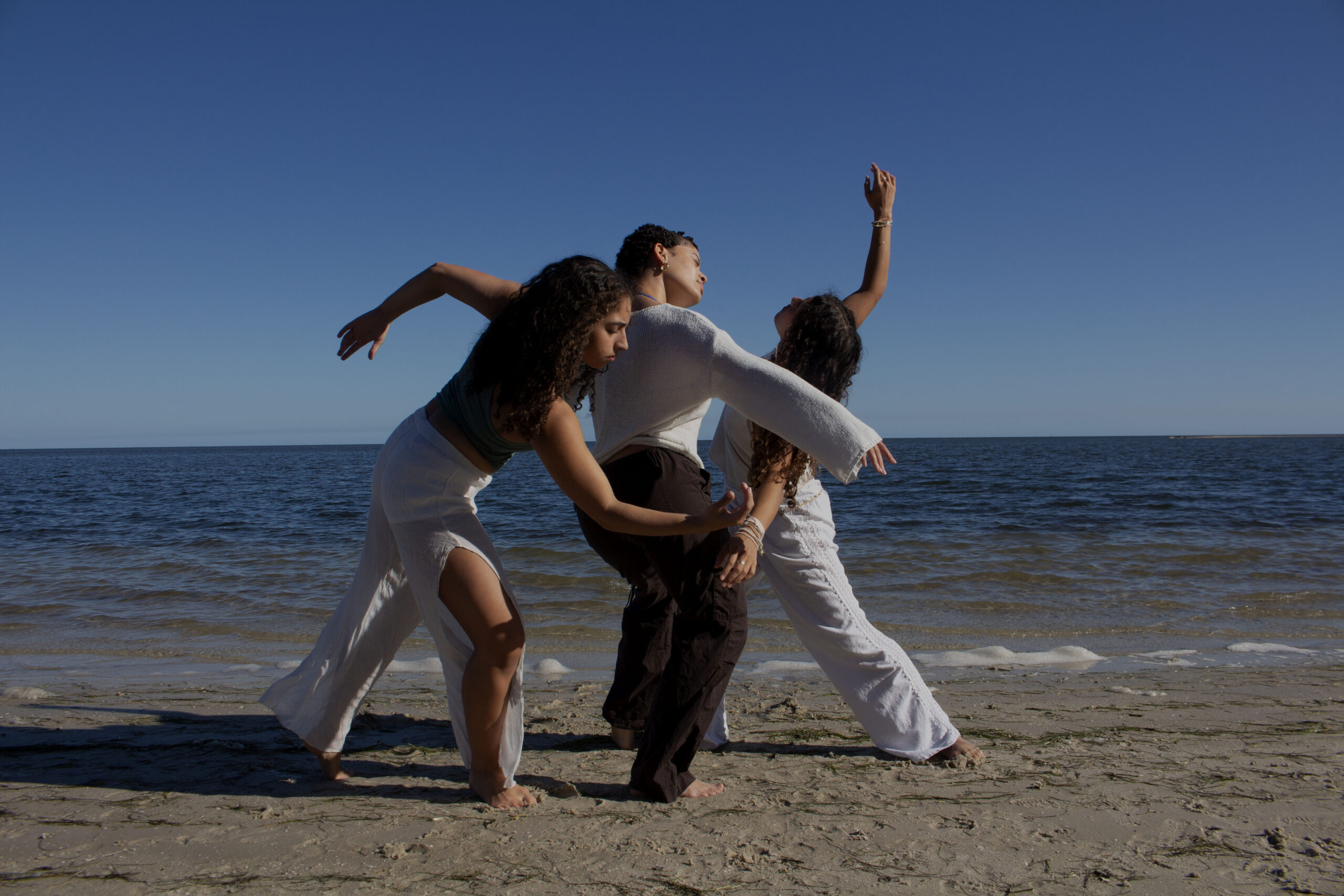 Three dancers on the beach