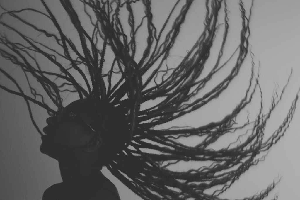 A dancer in silhouette flipping back her long hair.