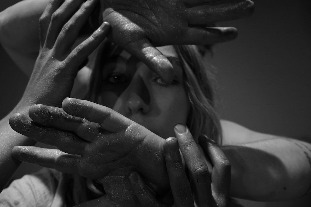 A close up image of a dancer looking through hands