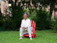 Jawole Willa Jo Zollar seated on FSU's campus in a red chair.