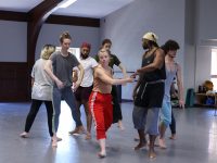 Dancers perform together in a studio